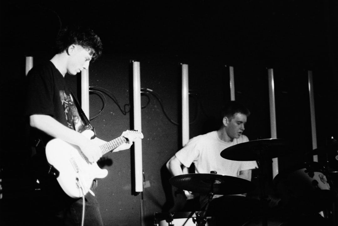 Two musicians performing on stage with instruments.