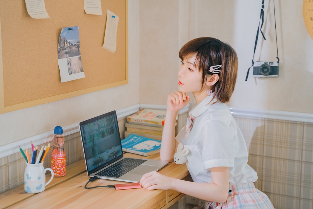 a girl sitting at a desk with a laptop