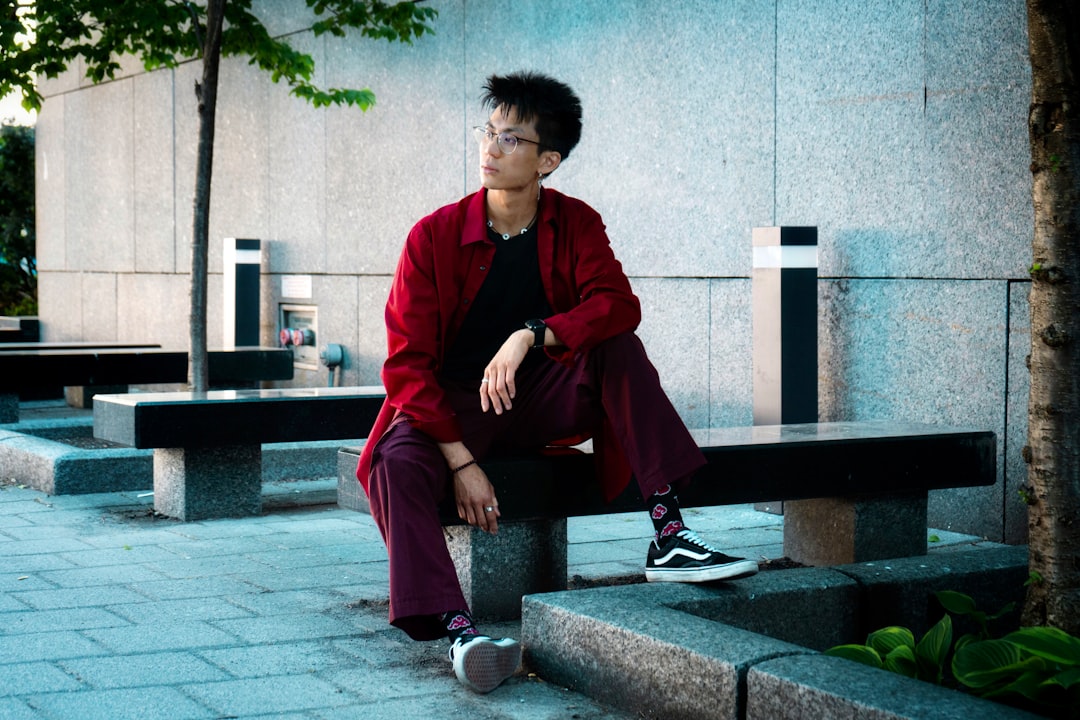 a man sitting on a bench in front of a building