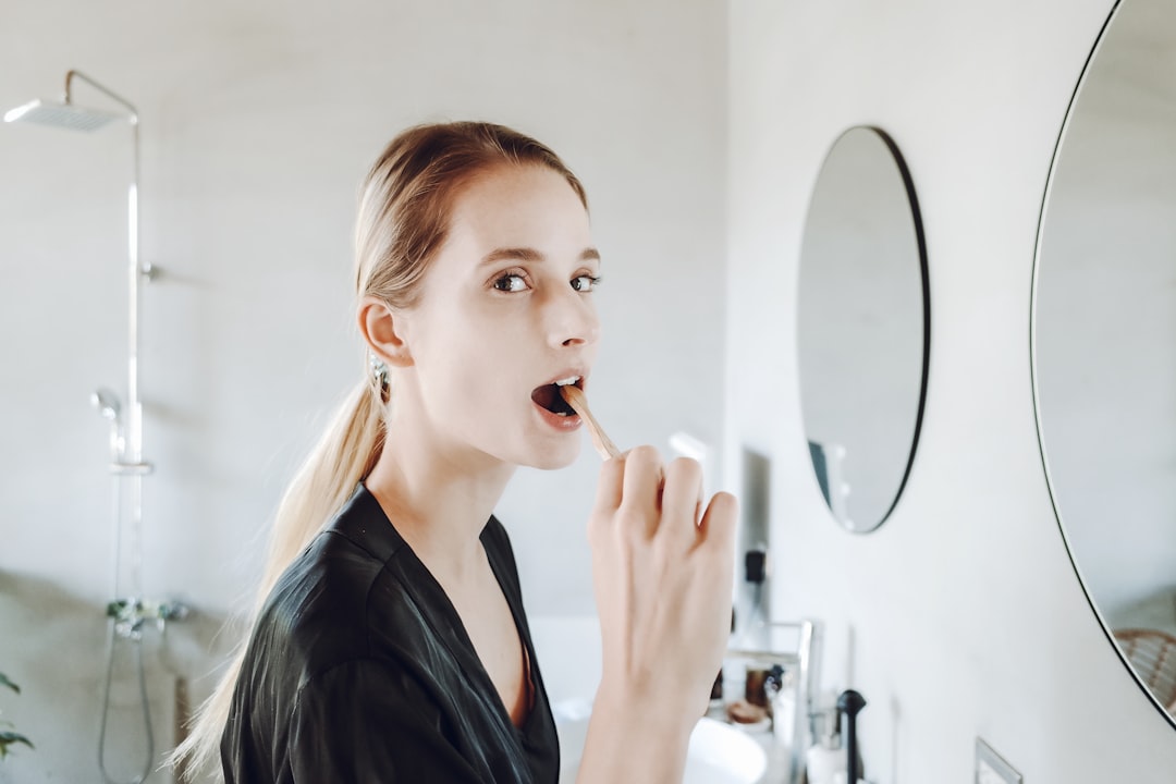 a woman brushing her teeth in front of a mirror