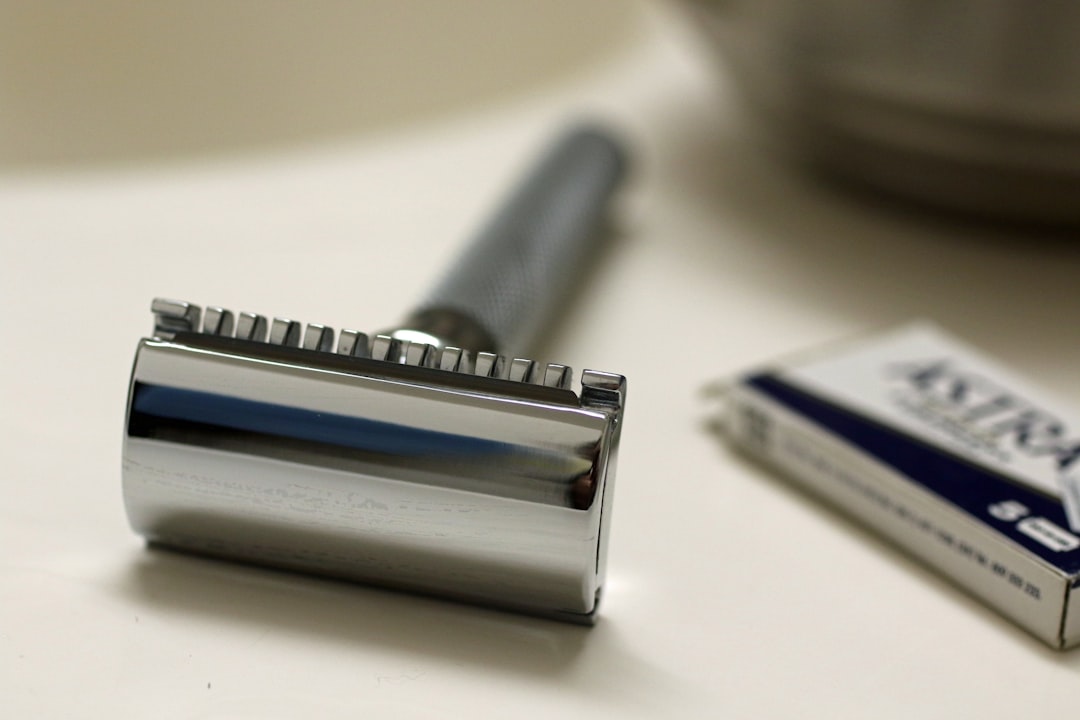 Chrome safety razor with blade packet on white surface