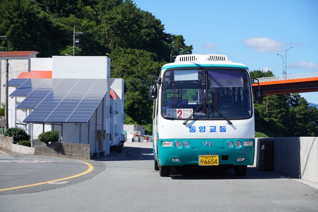 A bus parked near a building with solar panels.
