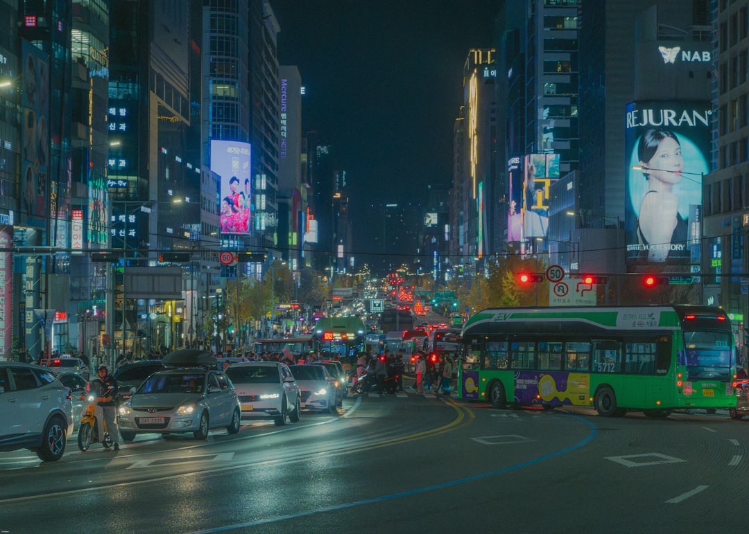Busy city street at night with traffic and neon lights