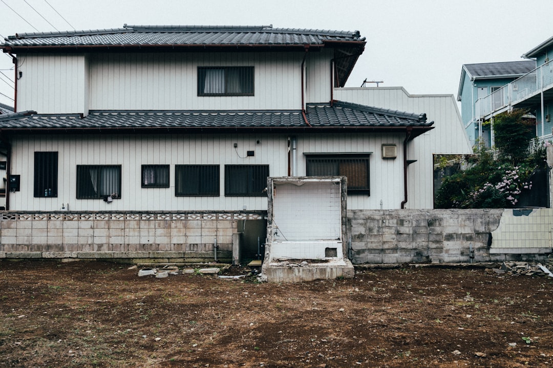 A white house with a black roof and a fence