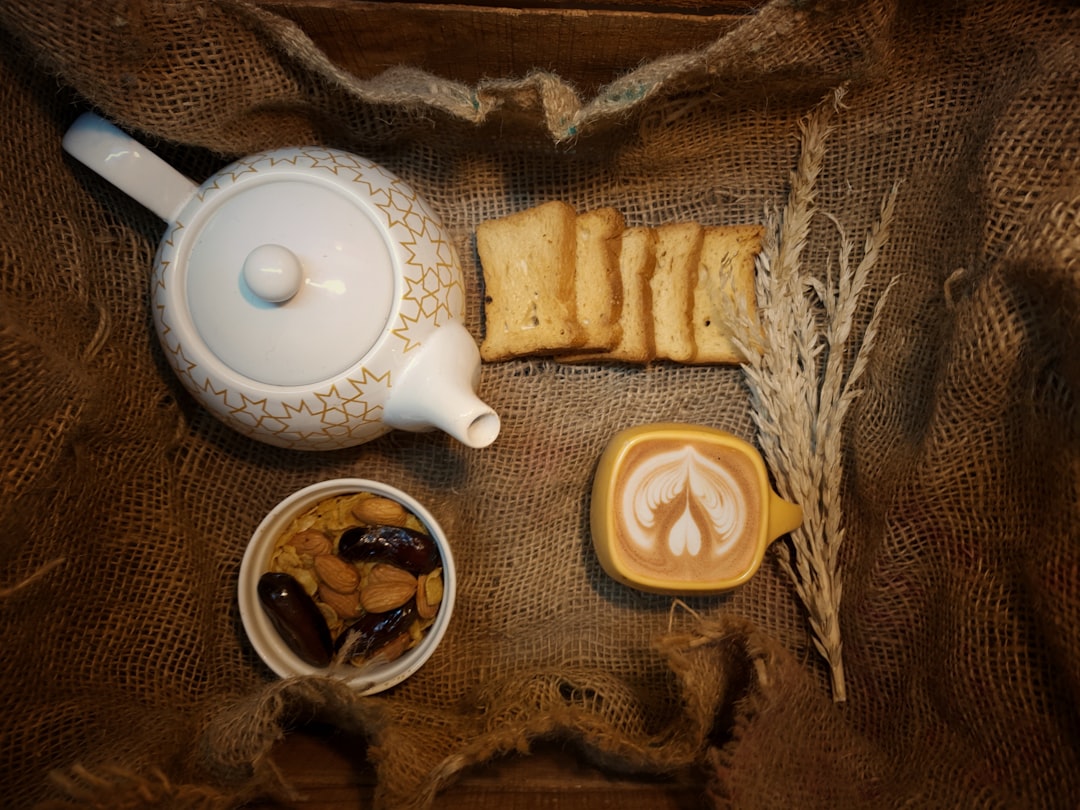 white ceramic teapot beside white ceramic teacup on saucer