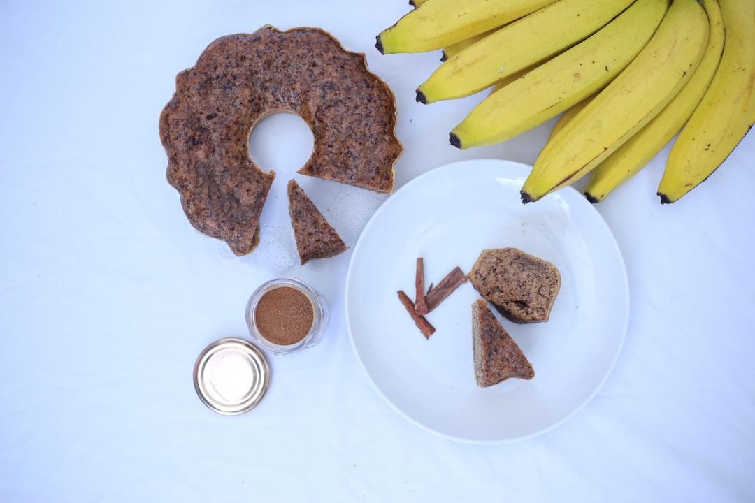 A white plate topped with food next to a bunch of bananas