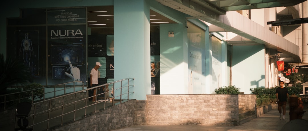 People walk past a building with a nura sign.
