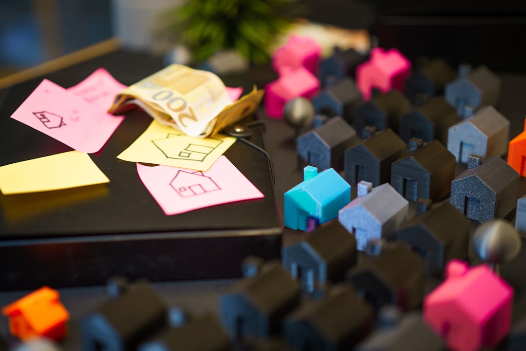 Miniature houses with euro banknotes and sticky notes.