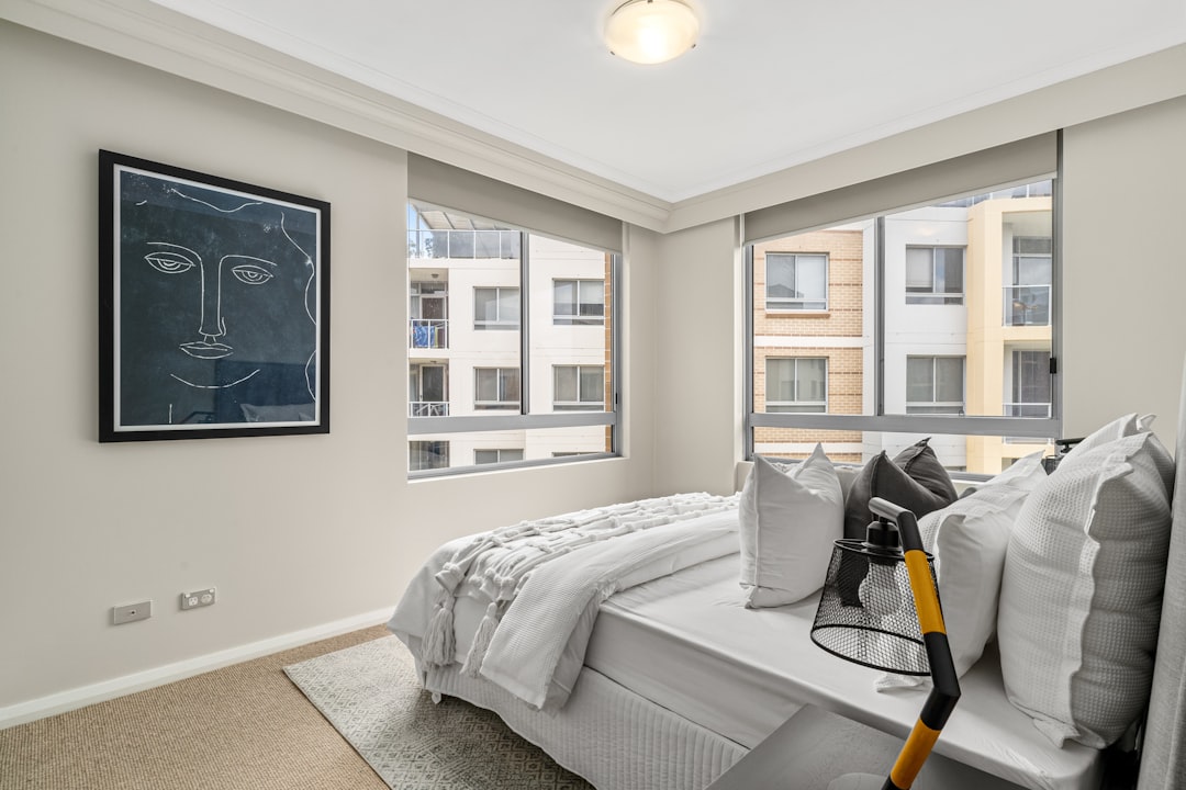 A bedroom with a large bed and large windows