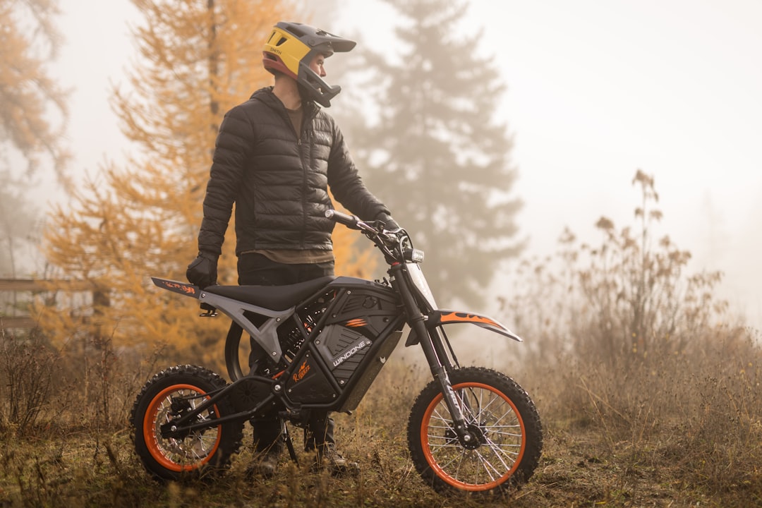 Man with dirt bike in autumn fog