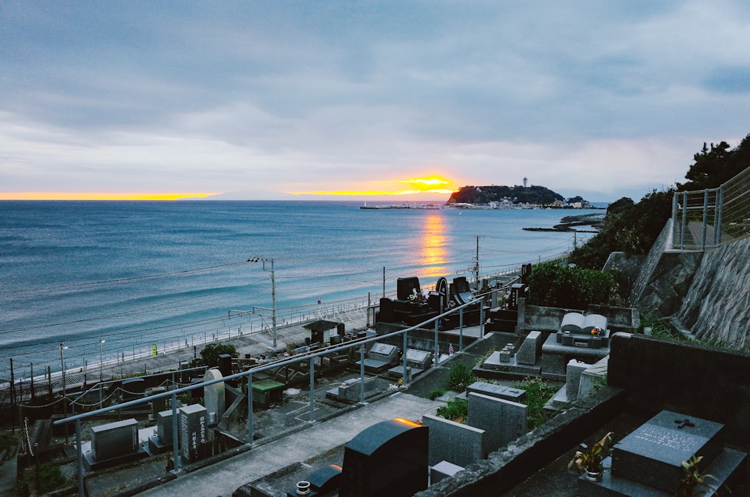 Sunset over the ocean with a coastal town.