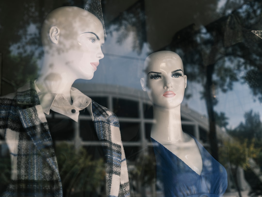 a couple of mannequins that are standing in front of a window
