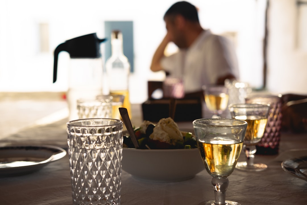 A man sitting at a table with glasses of wine