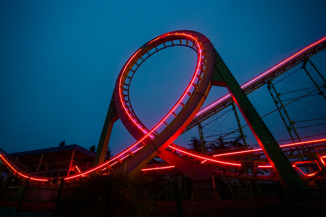 a roller coaster lit up at night with red lights