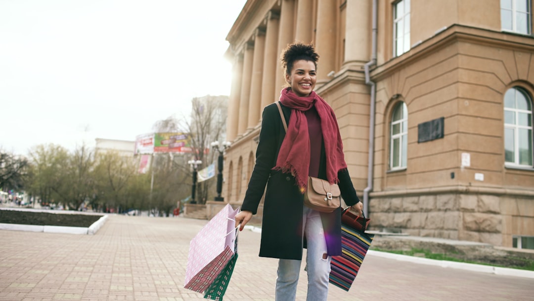 Woman walking with shopping bags outside building