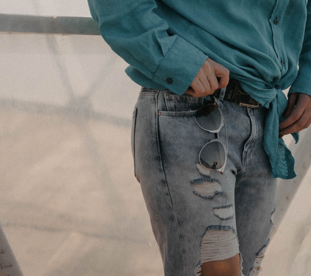 a woman wearing a blue shirt and ripped jeans