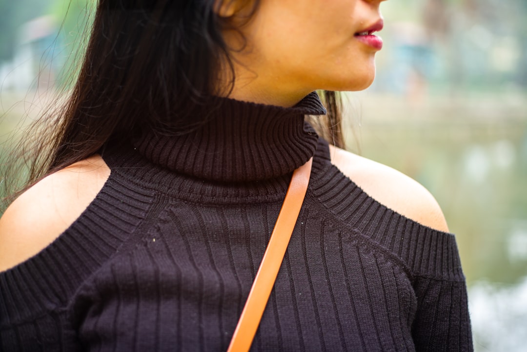 A woman in a black shoulder-cut sweater.