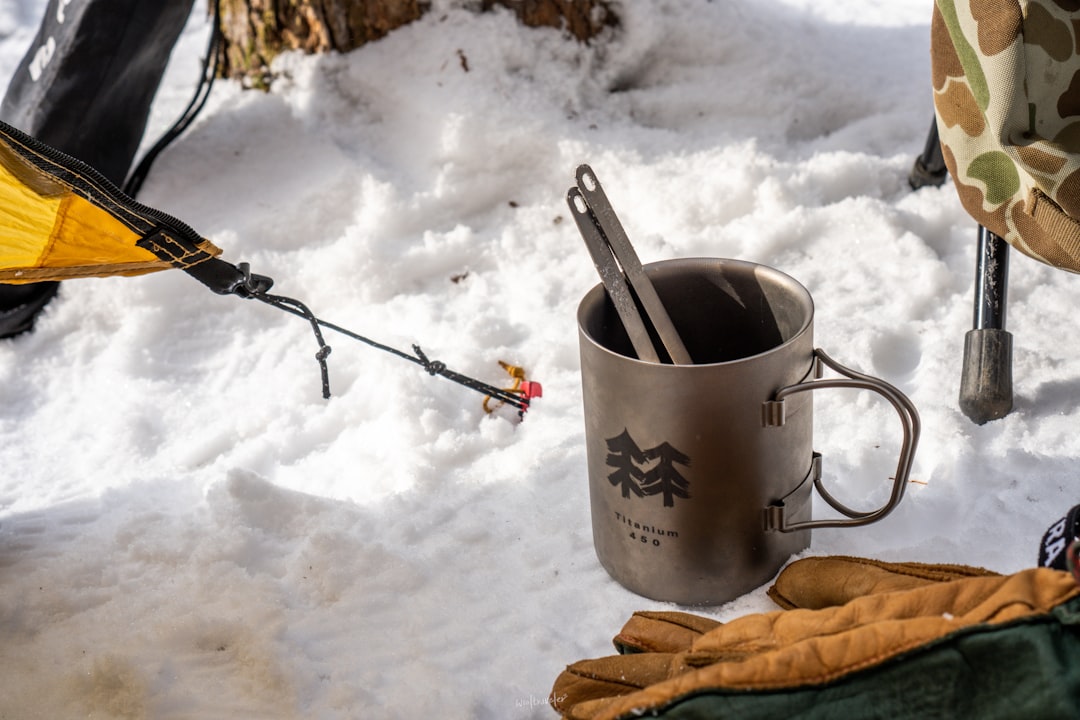 a camping cup with a spoon and a fork in it