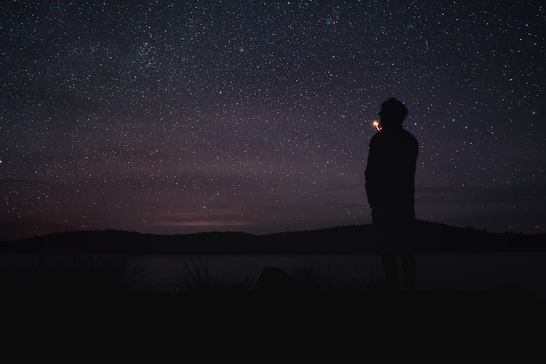 A person standing in the dark looking at the stars