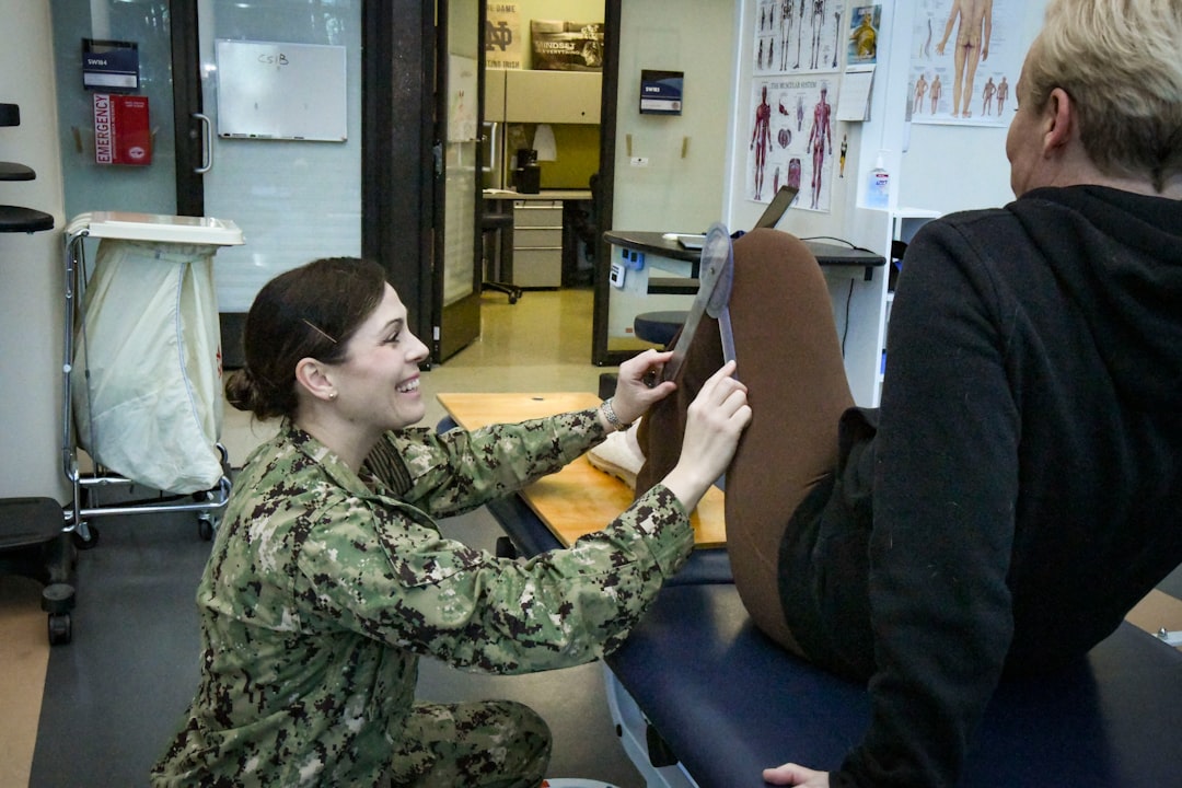 A physical therapist measures a patient's leg.