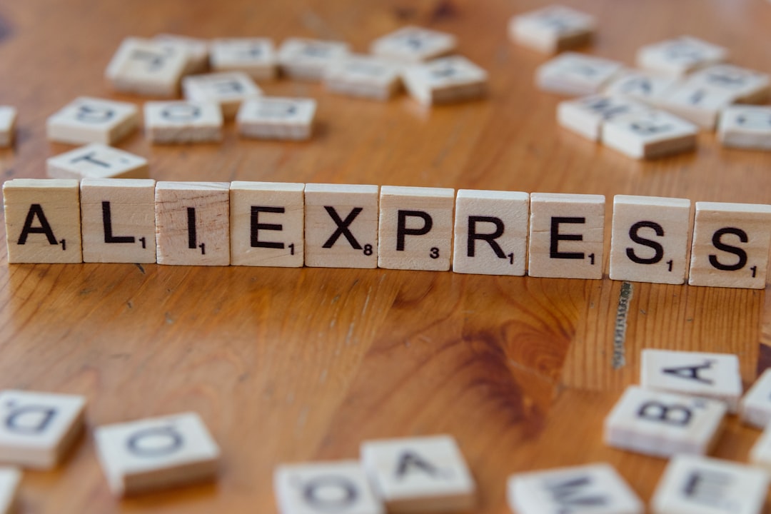A wooden block spelling the word allexpress on a table