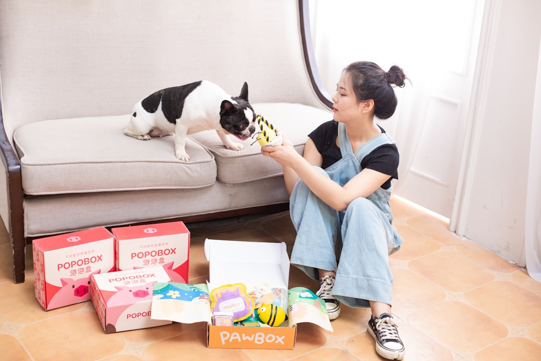 Woman and dog enjoying toys from a pet box.