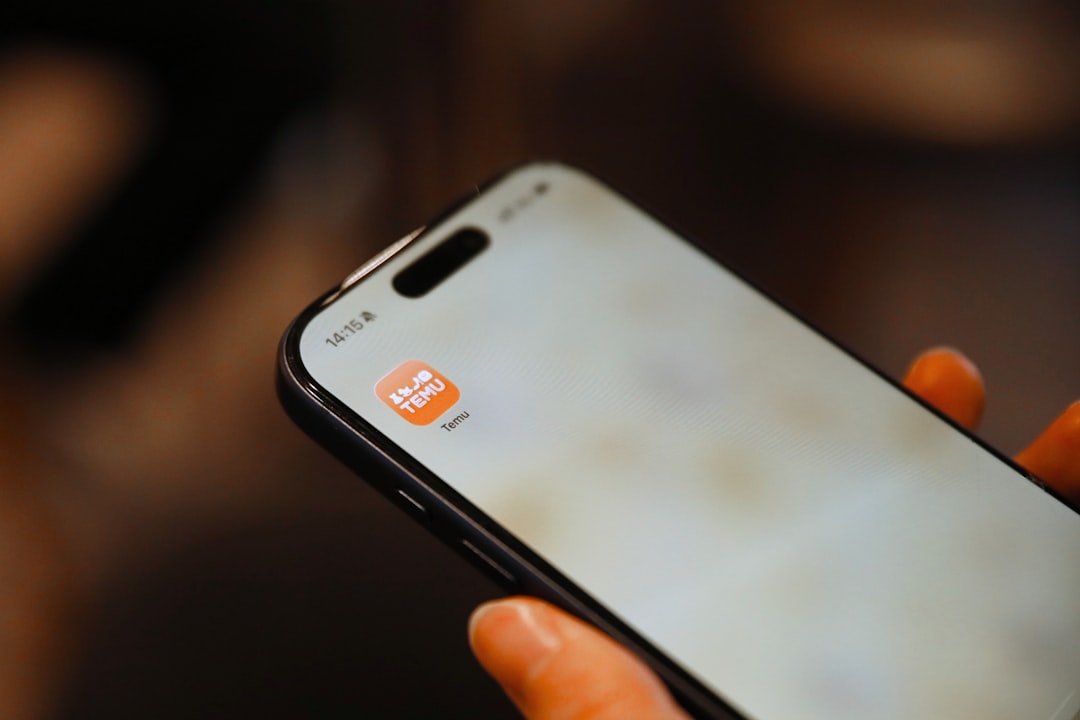 Person holding a smartphone with an app icon.