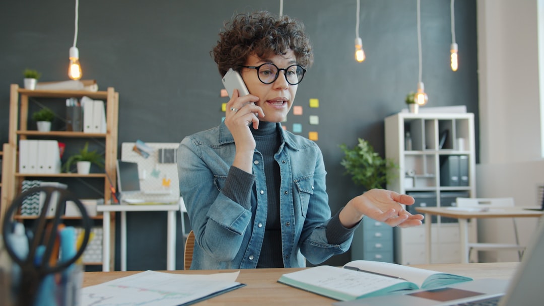 Woman talking on phone at desk in office