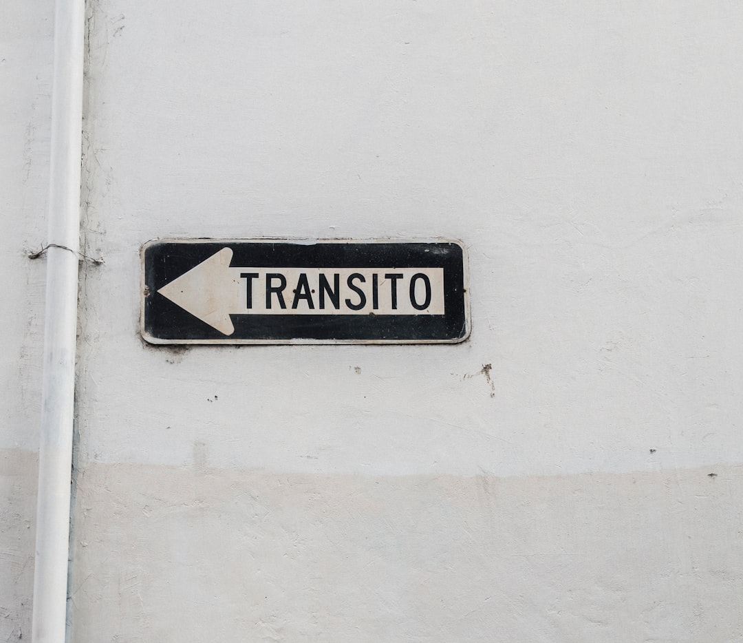 white and black Transito arrow sign