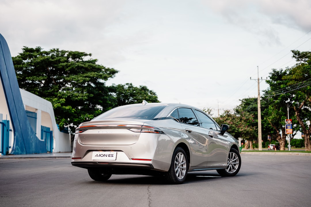 A modern silver sedan parked on a paved road.