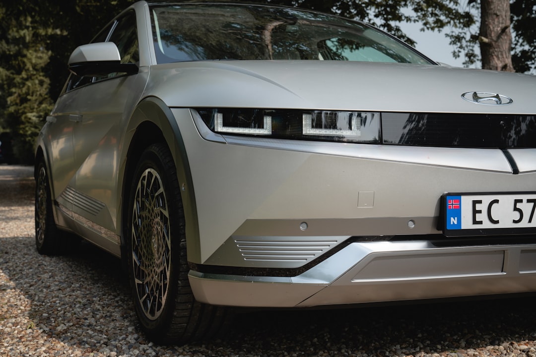 White electric car parked on gravel road.
