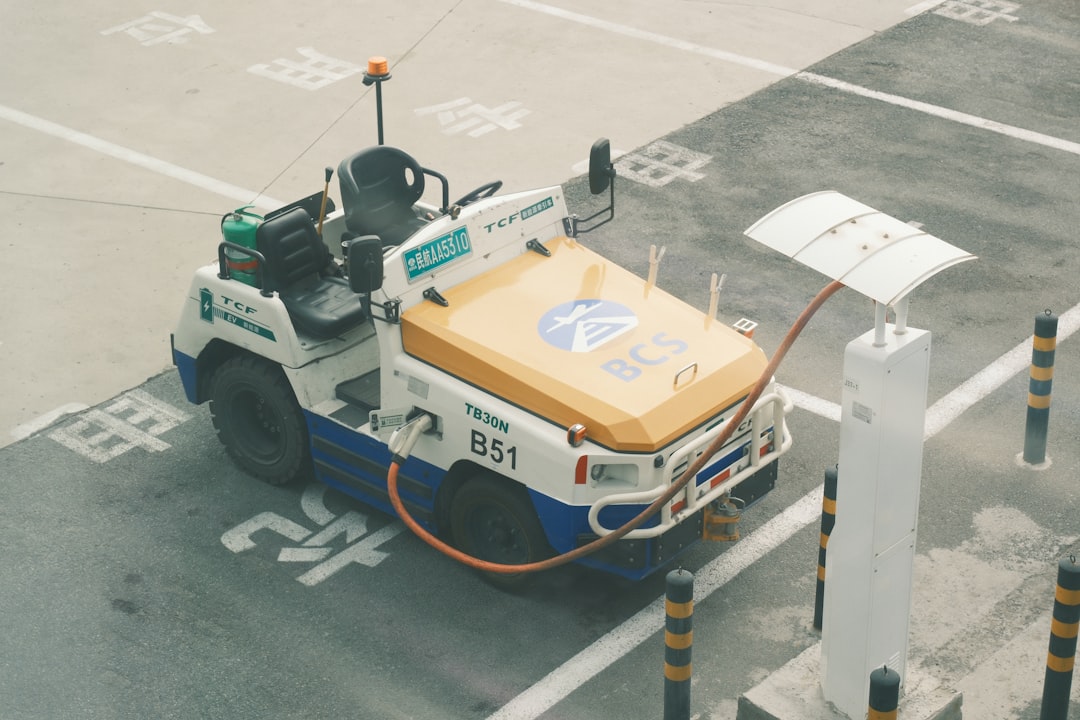A white and yellow utility vehicle parked on pavement.