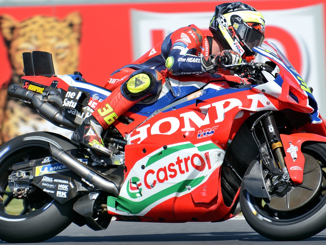 Motorcyclist in red racing suit on red honda motorcycle