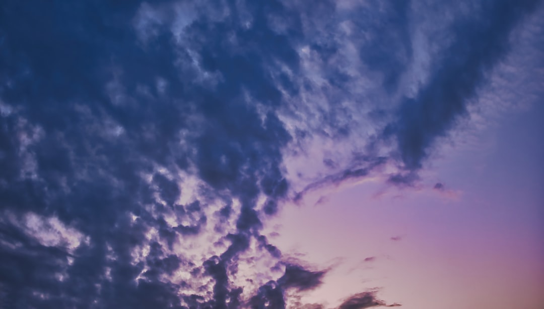 a plane flying in the sky at sunset