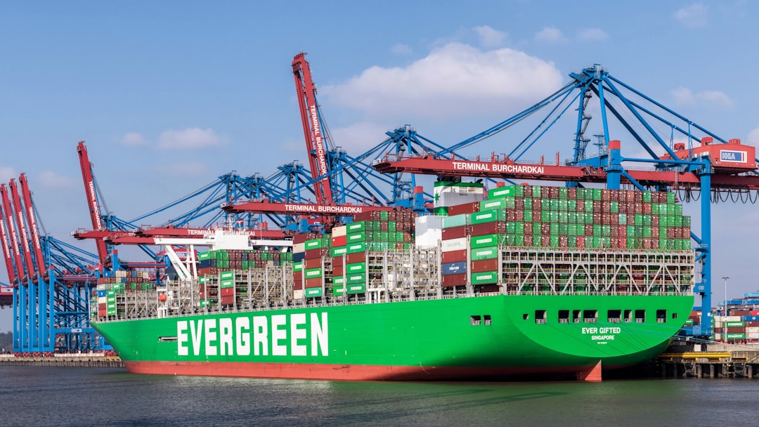 A large green cargo ship docked at a dock