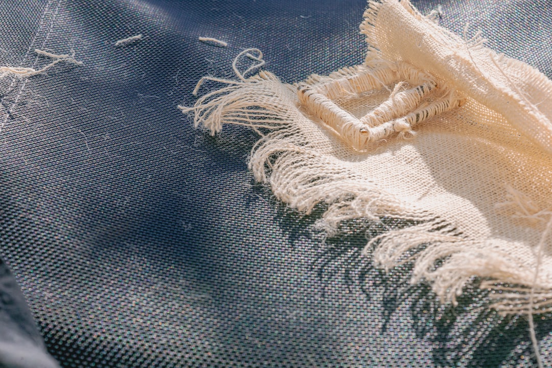 Close-up of ripped denim fabric with frayed threads.