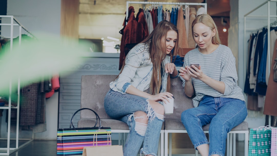Two women are looking at a phone in a store.