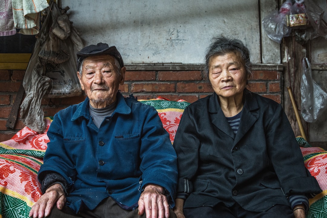 senior couple sitting on sofa beside wall