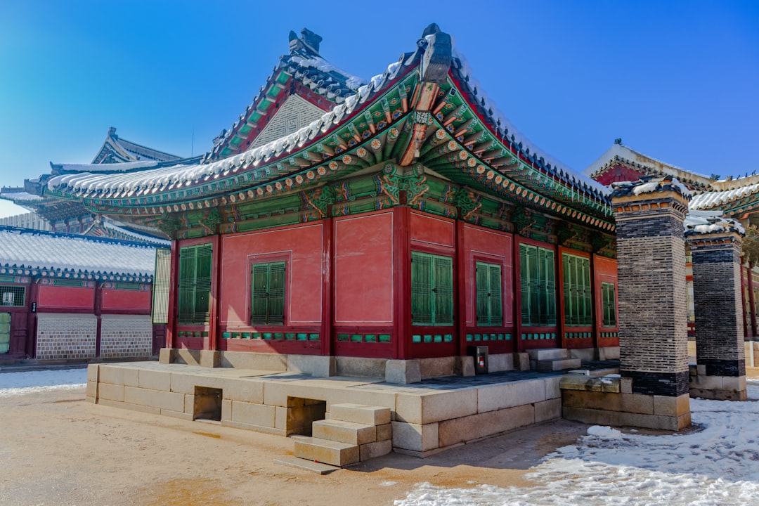 A red building with a green roof in the snow