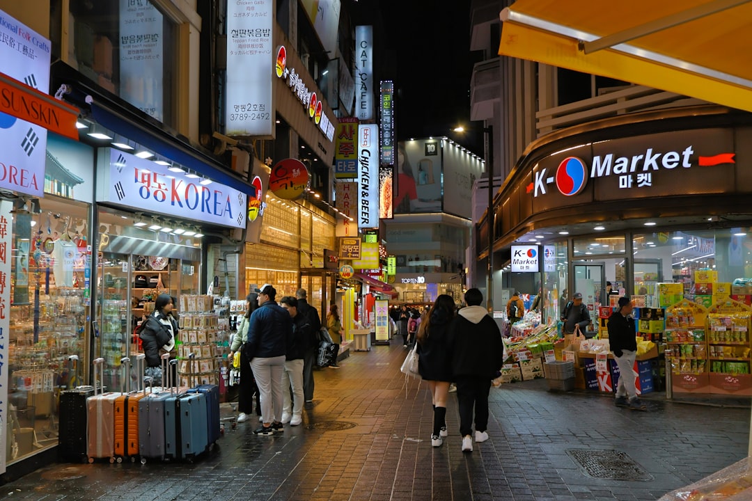 People walk down a busy street at night.