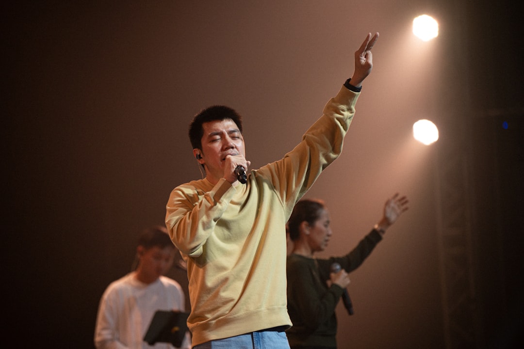 Man singing with hand raised on stage