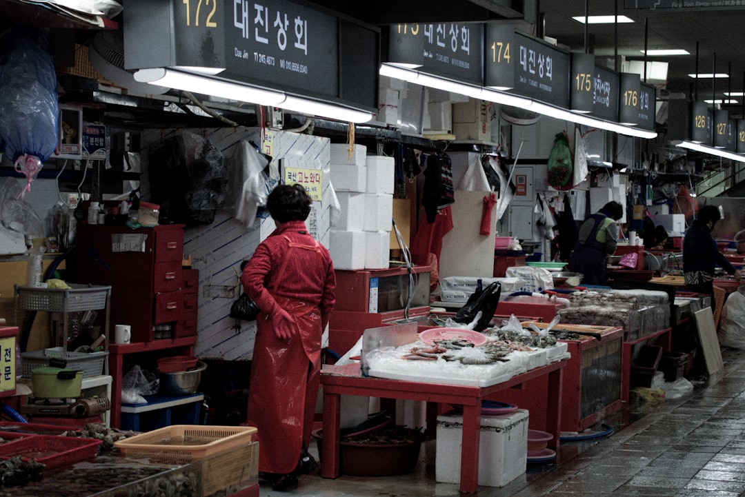 a man in a red coverall standing in a fish market