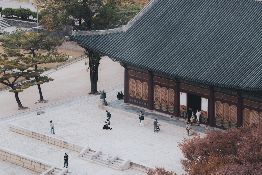 People gathered in courtyard of traditional korean palace building.