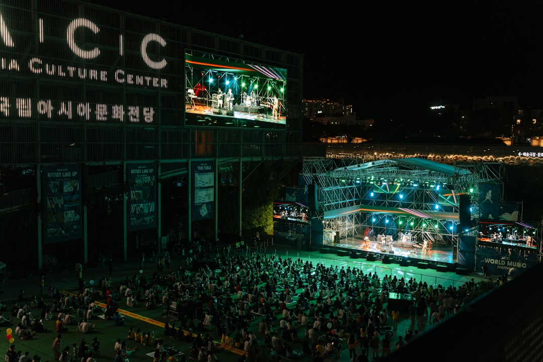 a crowd of people standing around a stage at night