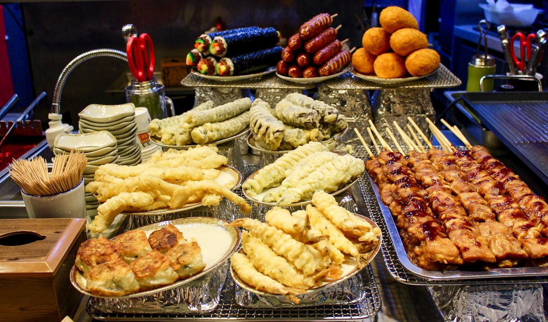 Assortment of korean street food, including skewers and fried items.