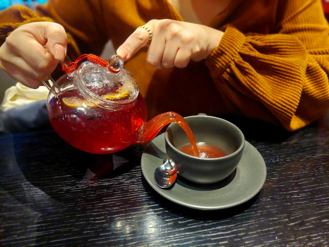 Someone is pouring a red tea into a cup.