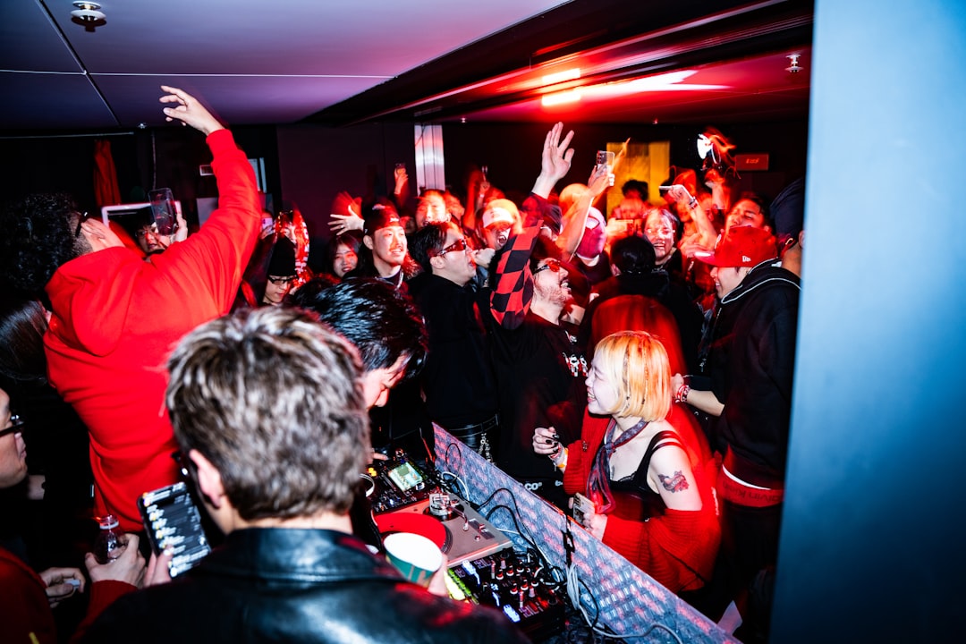 People dancing at a crowded nightclub with dj