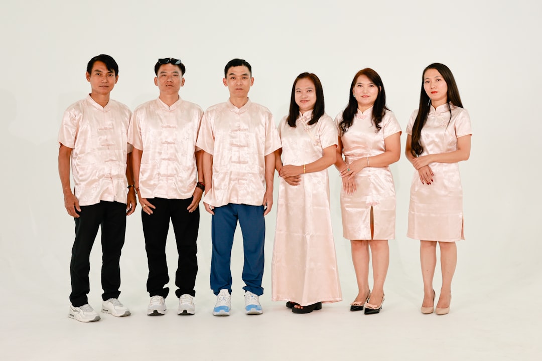 Six people in matching light pink outfits