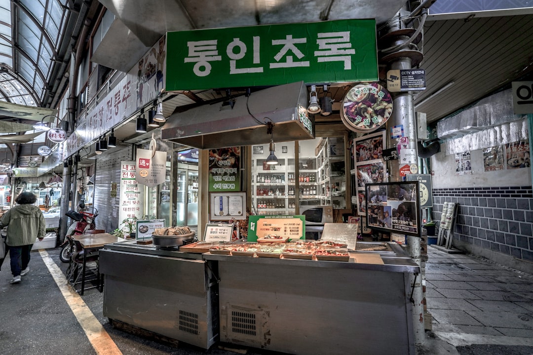 Small market stall with korean signage and english signs.