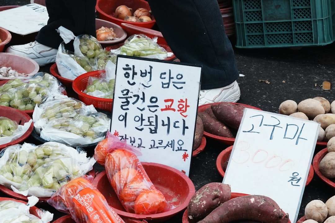 Fresh produce including sweet potatoes and grapes at a market.